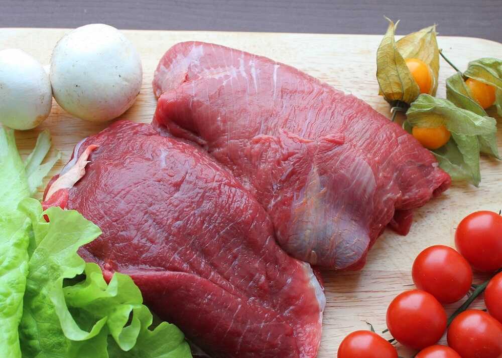 Два куска свежего мяса на деревянной доске