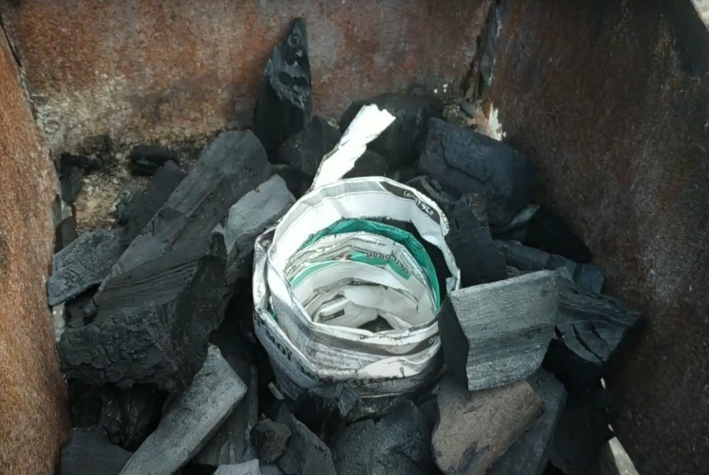 Газета сложенная по спирали в углях